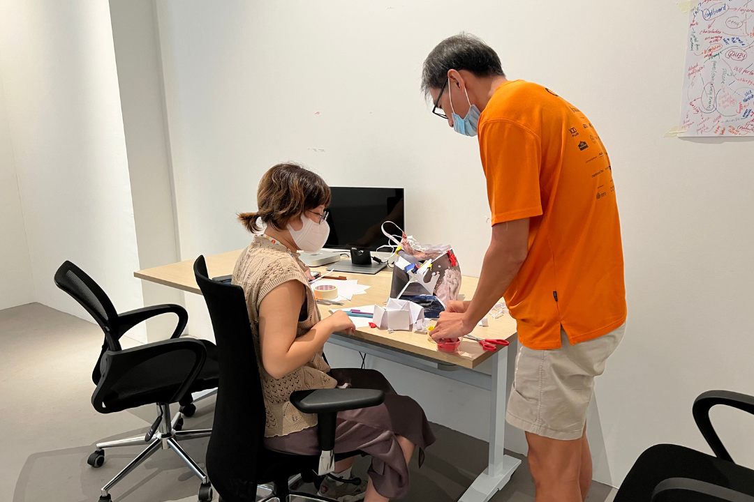 Aki guiding participants how to digitally record their sculptural objects for a smoother rendering on software.