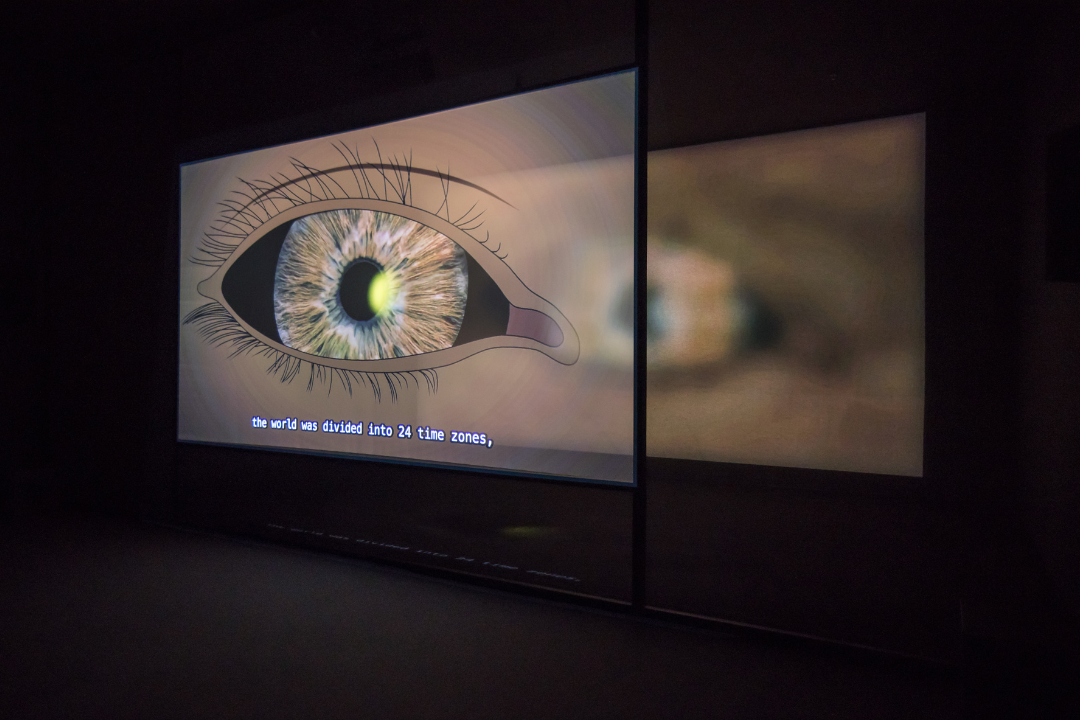Ho Tzu Nyen, 'T for Time', 2023–ongoing. Two-channel synchronised HD video, eight-channel sound, voile screen, scrim walls, real-time algorithmic editing and compositing system. Generative, 60 min cycles. Installation view at 'Ho Tzu Nyen: Time & the Tiger', SAM at Tanjong Pagar Distripark, 24 Nov 2023‒3 Mar 2024. Image courtesy of Singapore Art Museum.